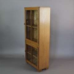A 1930's Heals two door light oak glazed bookcase with label to door