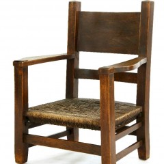 An Arts and Crafts oak 'mission' armchair,with a woven string seat