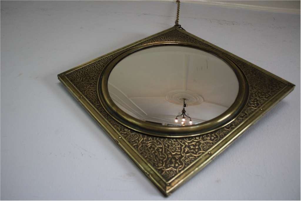 Convex mirror with chased brass frame. Early 20th century