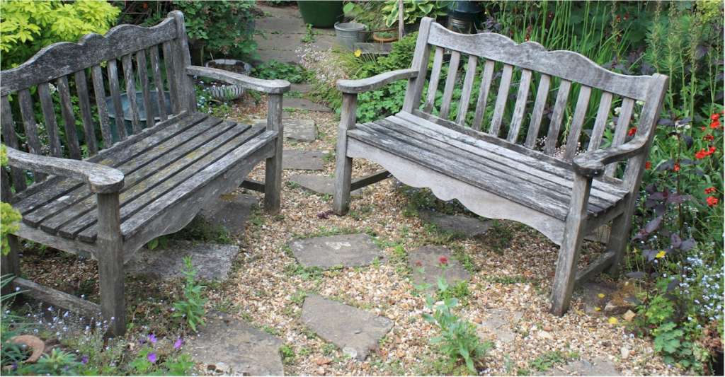 Pair of Teak garden benches with oak leaf decoration