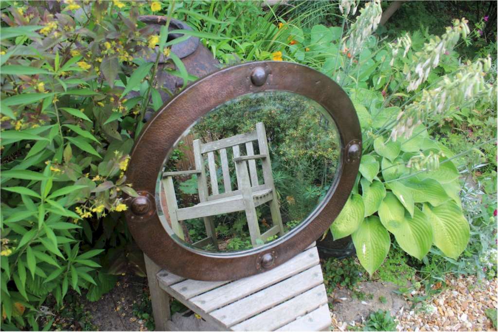 Arts and crafts oval copper mirror with raised roundels