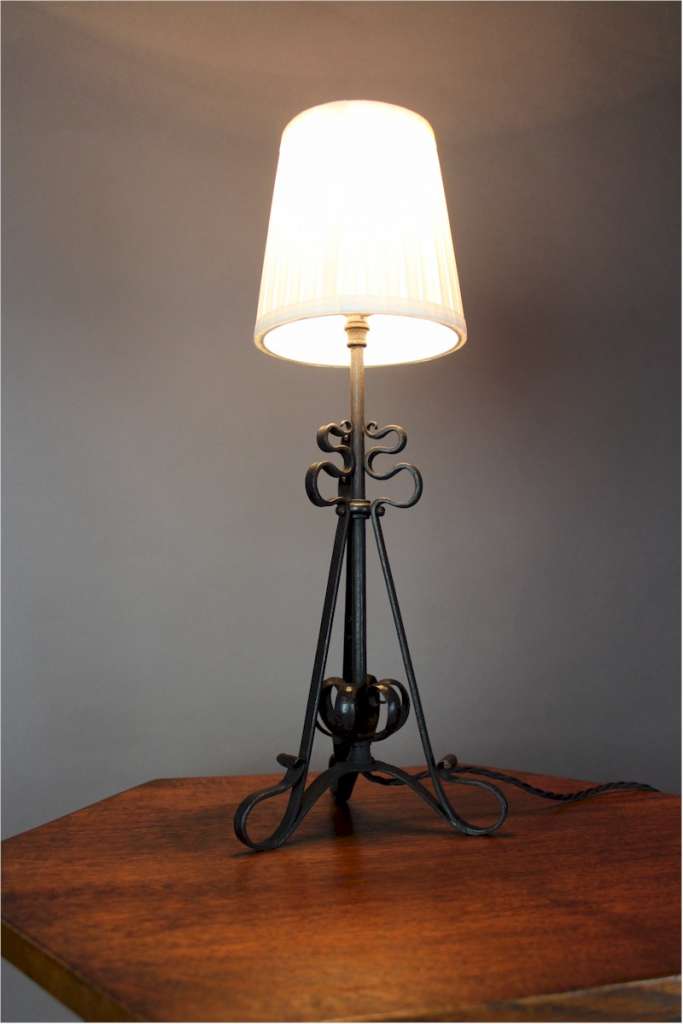 Arts and crafts iron table lamp with scrolling supports c1900