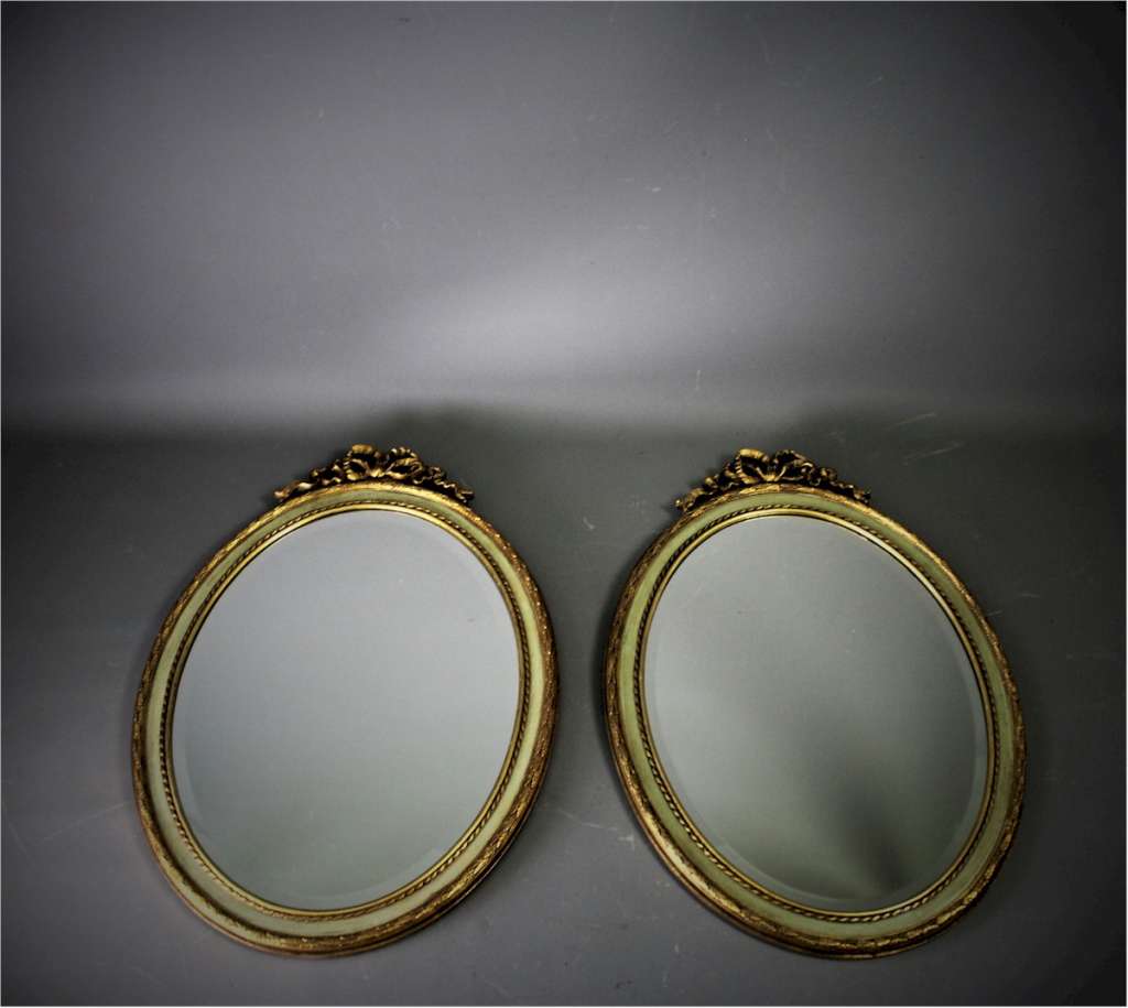 Pair of French gilt and painted wood oval mirrors